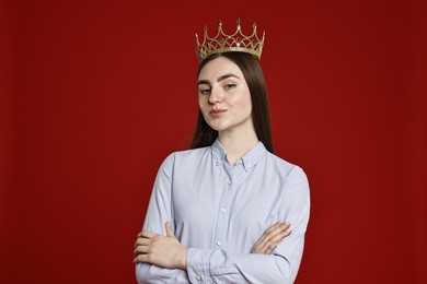 Photo of Woman in elegant crown on dark red background