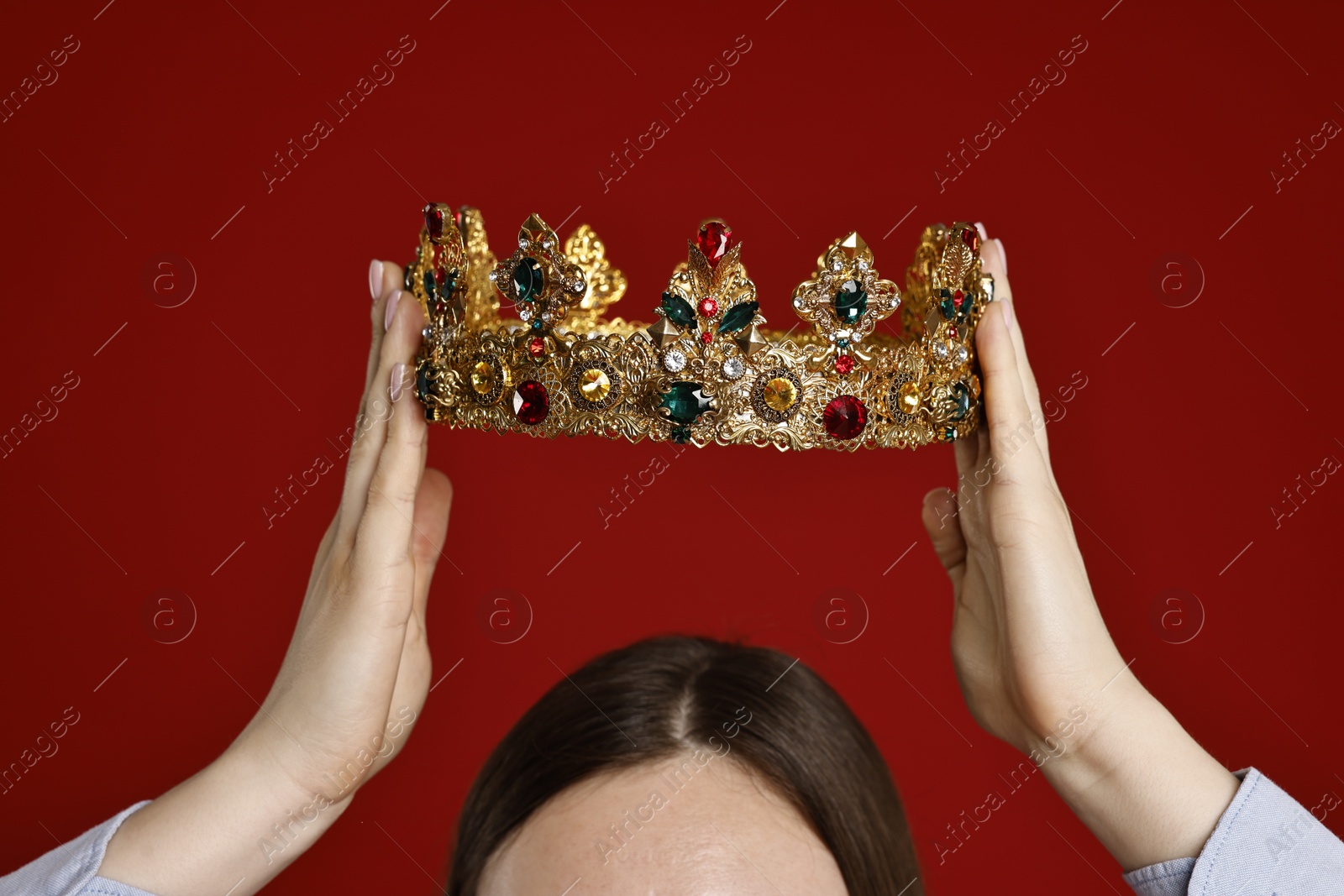 Photo of Woman wearing elegant crown on dark red background, closeup