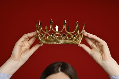 Photo of Woman wearing elegant crown on dark red background, closeup