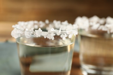 Photo of Tequila shots with salt on table, closeup