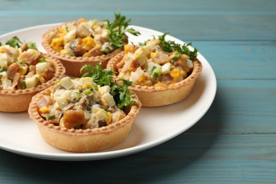 Photo of Tartlets with delicious filling on blue wooden table, closeup