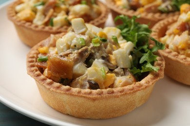 Photo of Tartlets with delicious filling on blue table, closeup