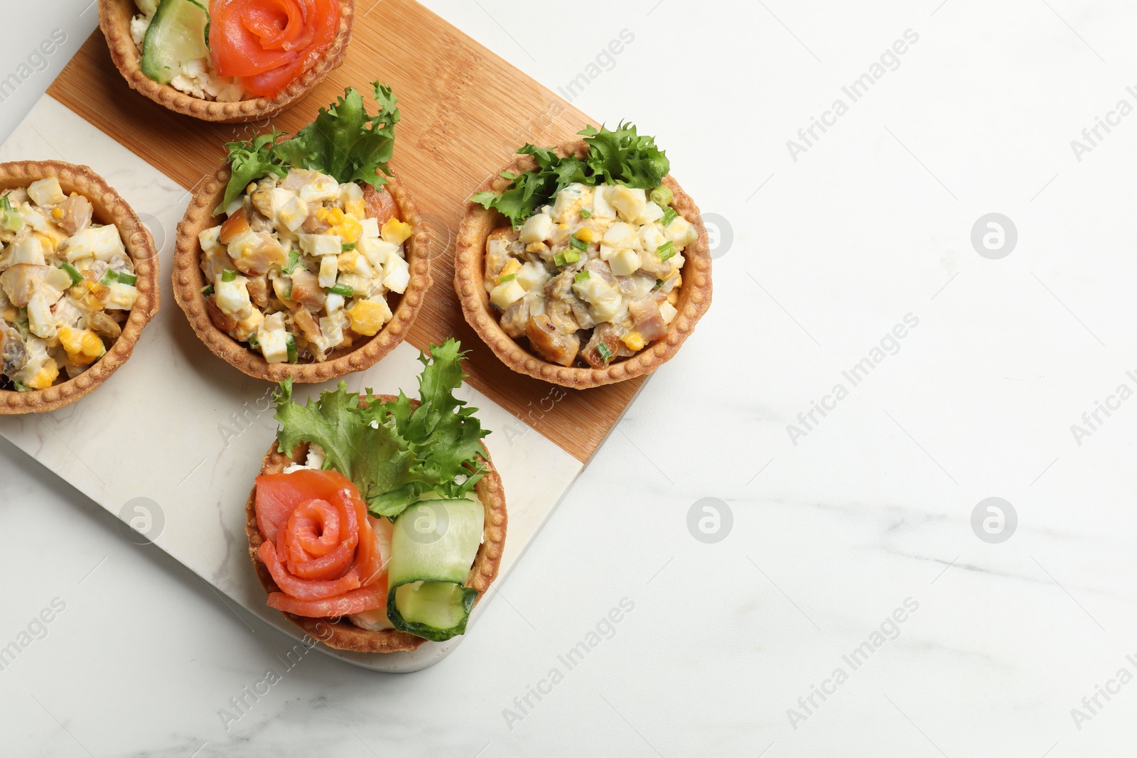 Photo of Tartlets with delicious fillings on white table, top view. Space for text