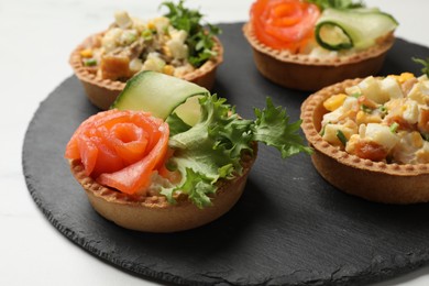 Photo of Tartlets with delicious fillings on white table, closeup