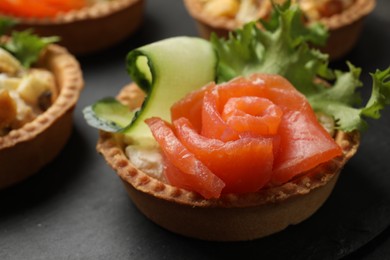 Photo of Tartlets with delicious filling on black table, closeup