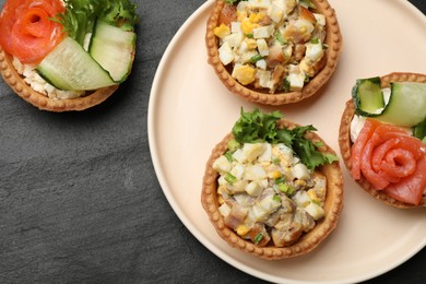 Photo of Tartlets with delicious fillings on black table, top view