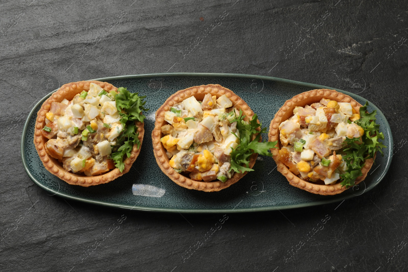 Photo of Tartlets with delicious filling on black table, top view