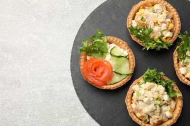 Photo of Tartlets with delicious fillings on grey table, top view. Space for text