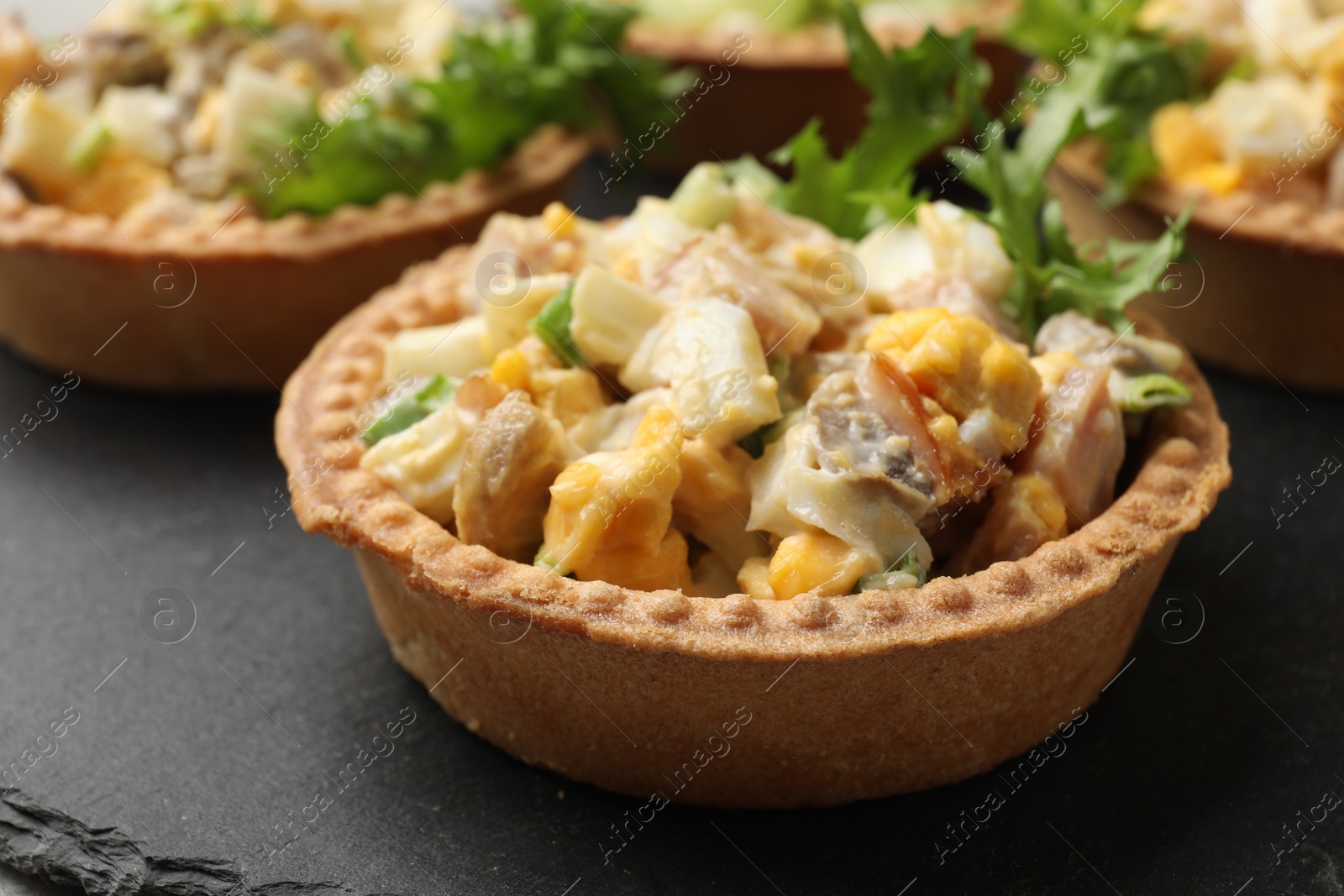 Photo of Tartlets with delicious filling on table, closeup