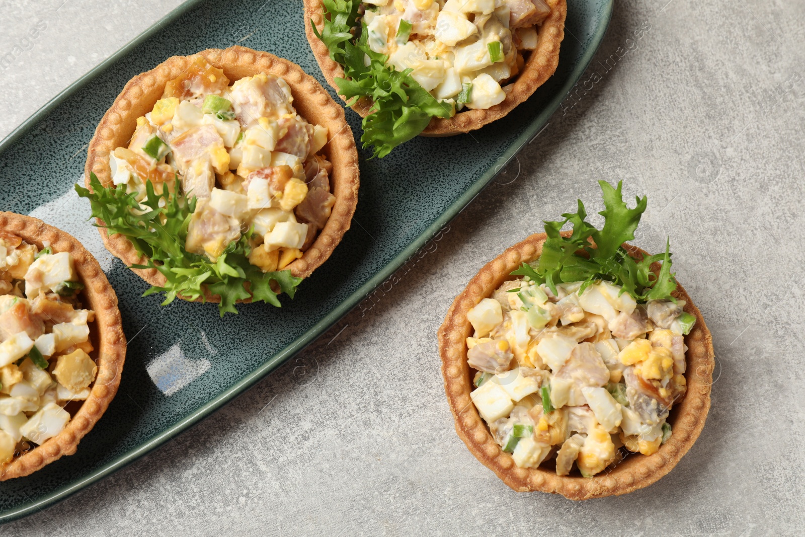 Photo of Tartlets with delicious filling on grey table, top view