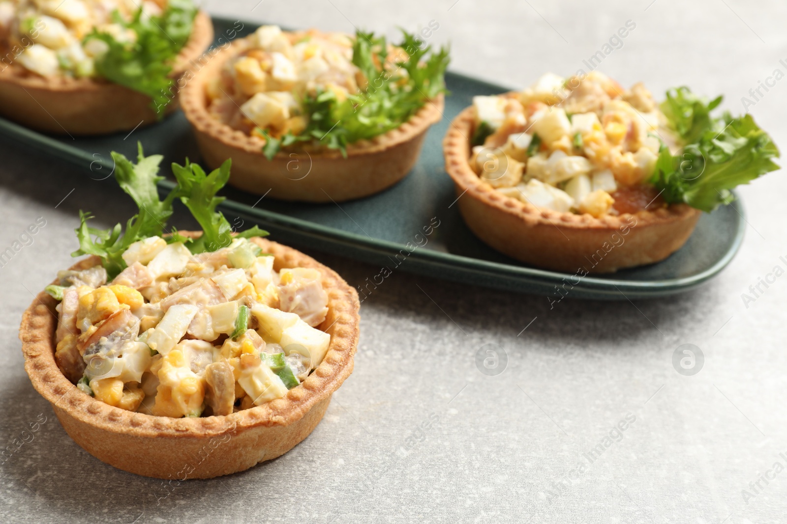 Photo of Tartlets with delicious filling on grey table, closeup