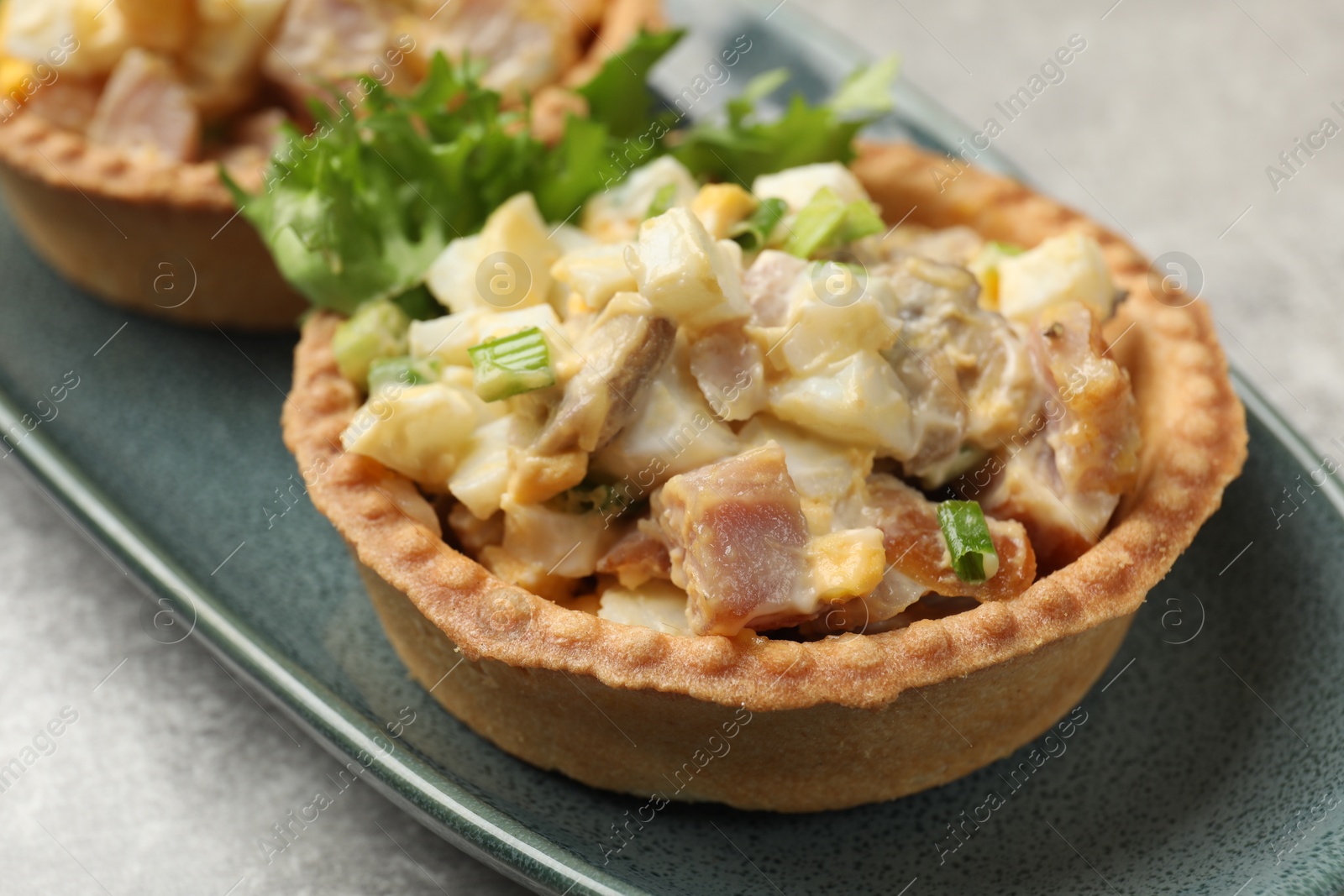 Photo of Tartlets with delicious filling on grey table, closeup