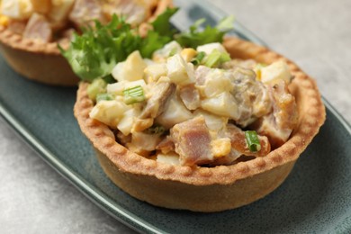 Photo of Tartlets with delicious filling on grey table, closeup