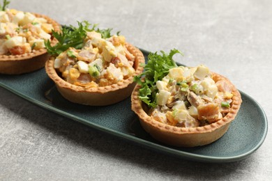 Photo of Tartlets with delicious filling on grey table, closeup