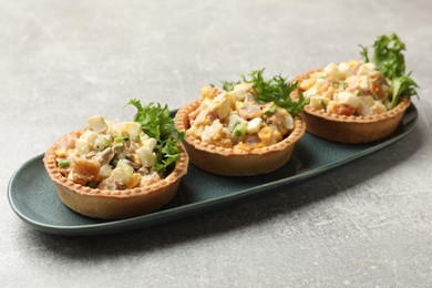 Photo of Tartlets with delicious filling on grey table, closeup