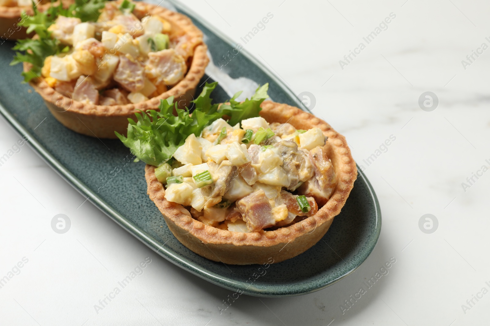 Photo of Tartlets with delicious filling on white marble table, closeup