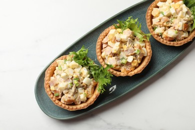 Photo of Tartlets with delicious filling on white marble table, top view