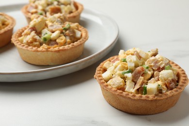 Photo of Tartlets with delicious filling on white marble table, closeup