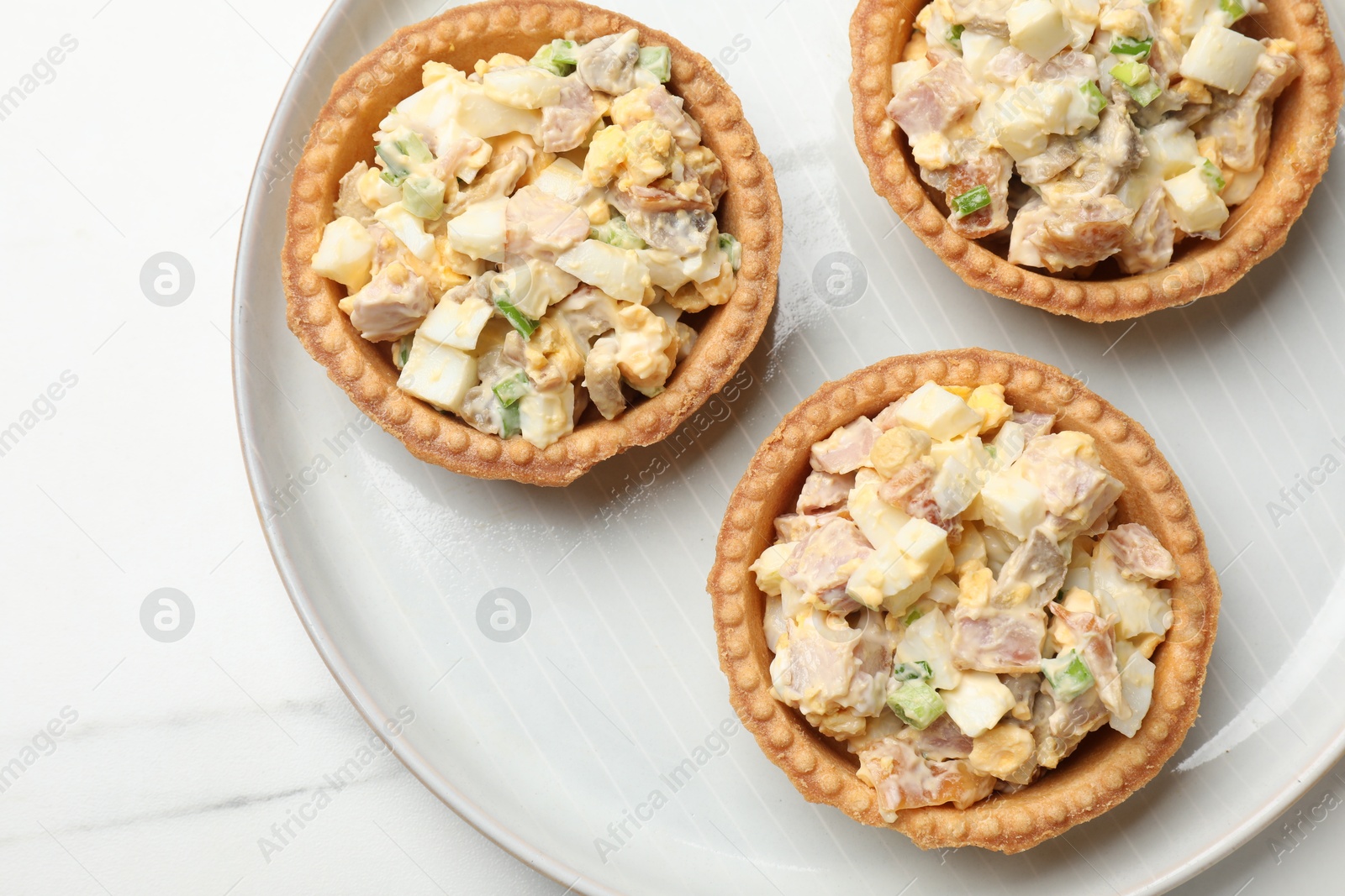 Photo of Tartlets with delicious filling on white marble table, top view