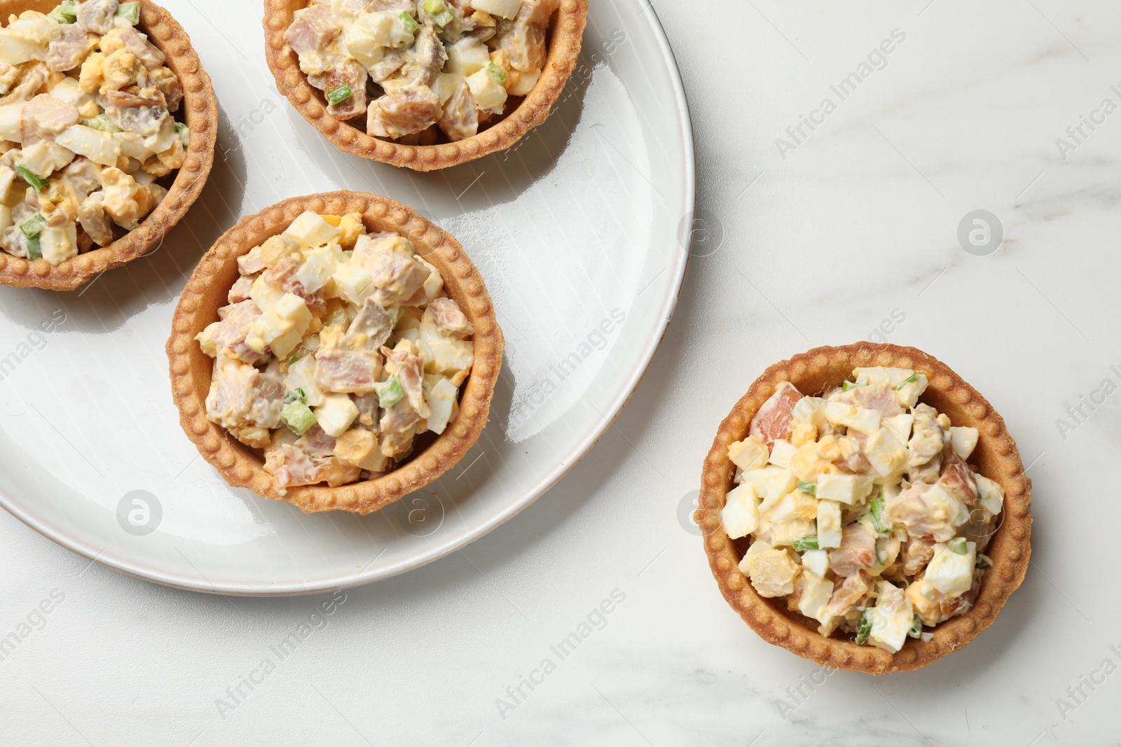 Photo of Tartlets with delicious filling on white marble table, top view