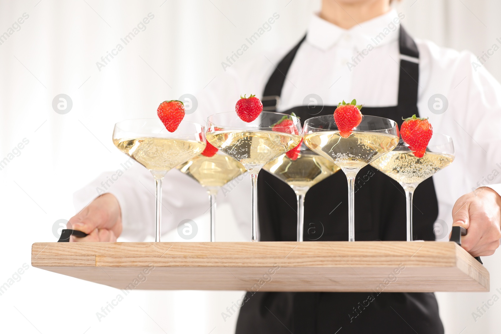 Photo of Waiter holding tray with glasses of champagne indoors, closeup