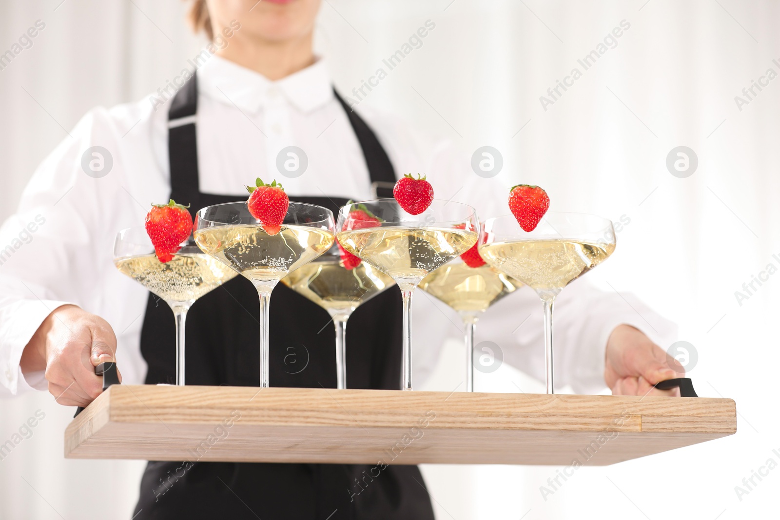 Photo of Waiter holding tray with glasses of champagne indoors, closeup