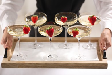 Photo of Waiter holding tray with glasses of champagne indoors, closeup