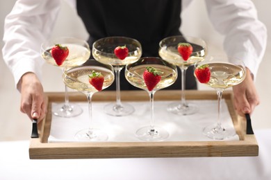 Photo of Waiter holding tray with glasses of champagne indoors, closeup