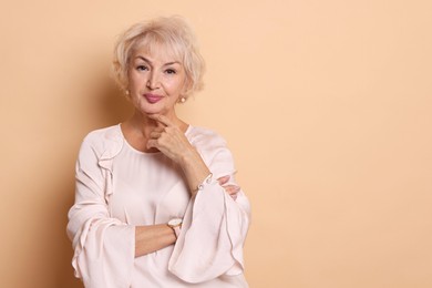 Photo of Portrait of elegant grandmother on beige background. Space for text