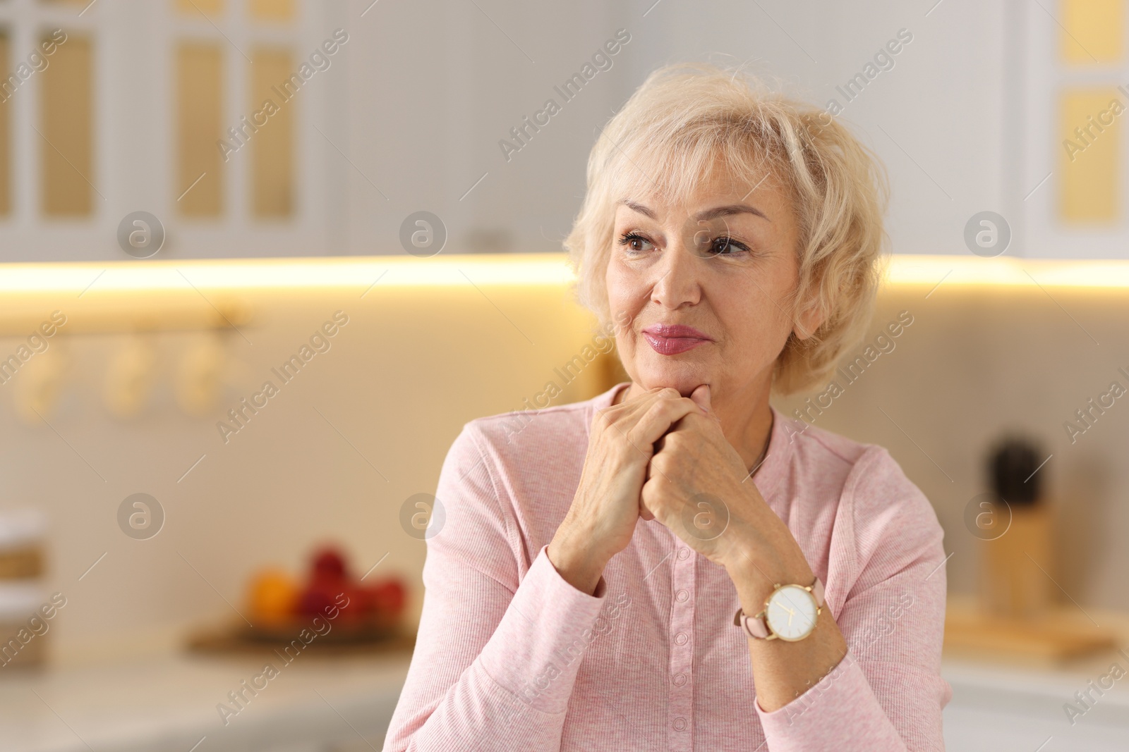 Photo of Portrait of beautiful grandmother in kitchen. Space for text