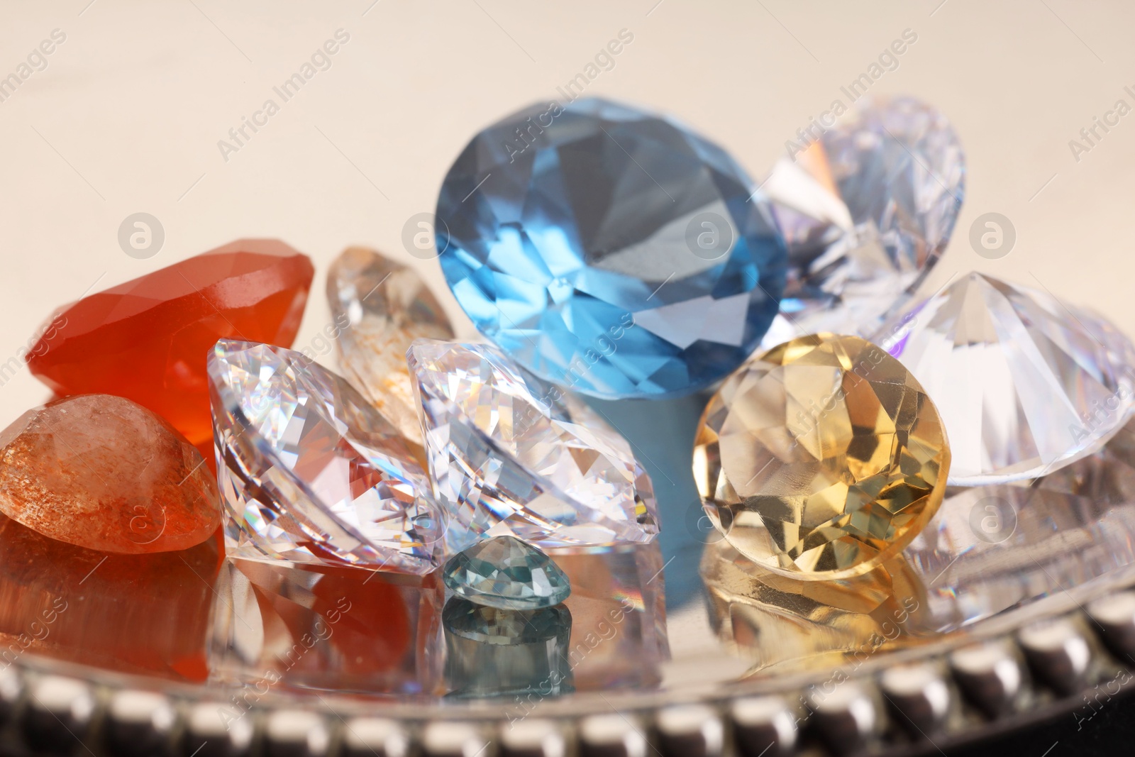 Photo of Beautiful shiny colorful gemstones on light background, closeup