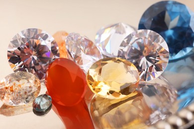 Photo of Beautiful shiny colorful gemstones on light background, closeup