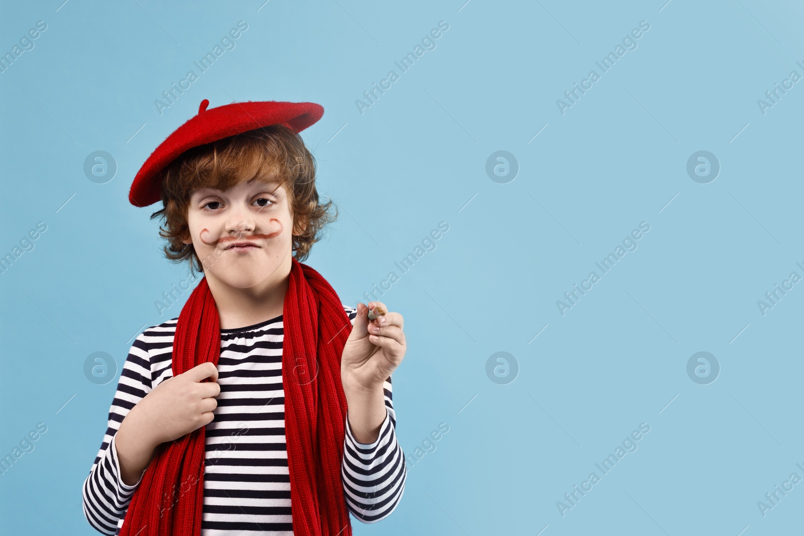 Photo of Cute boy in mime costume with brush on light blue background, space for text. Surprise party