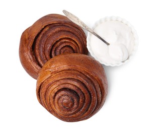 Photo of Tasty cinnamon rolls with cream isolated on white, top view