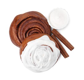 Photo of Tasty cinnamon rolls with cream and sticks isolated on white, top view