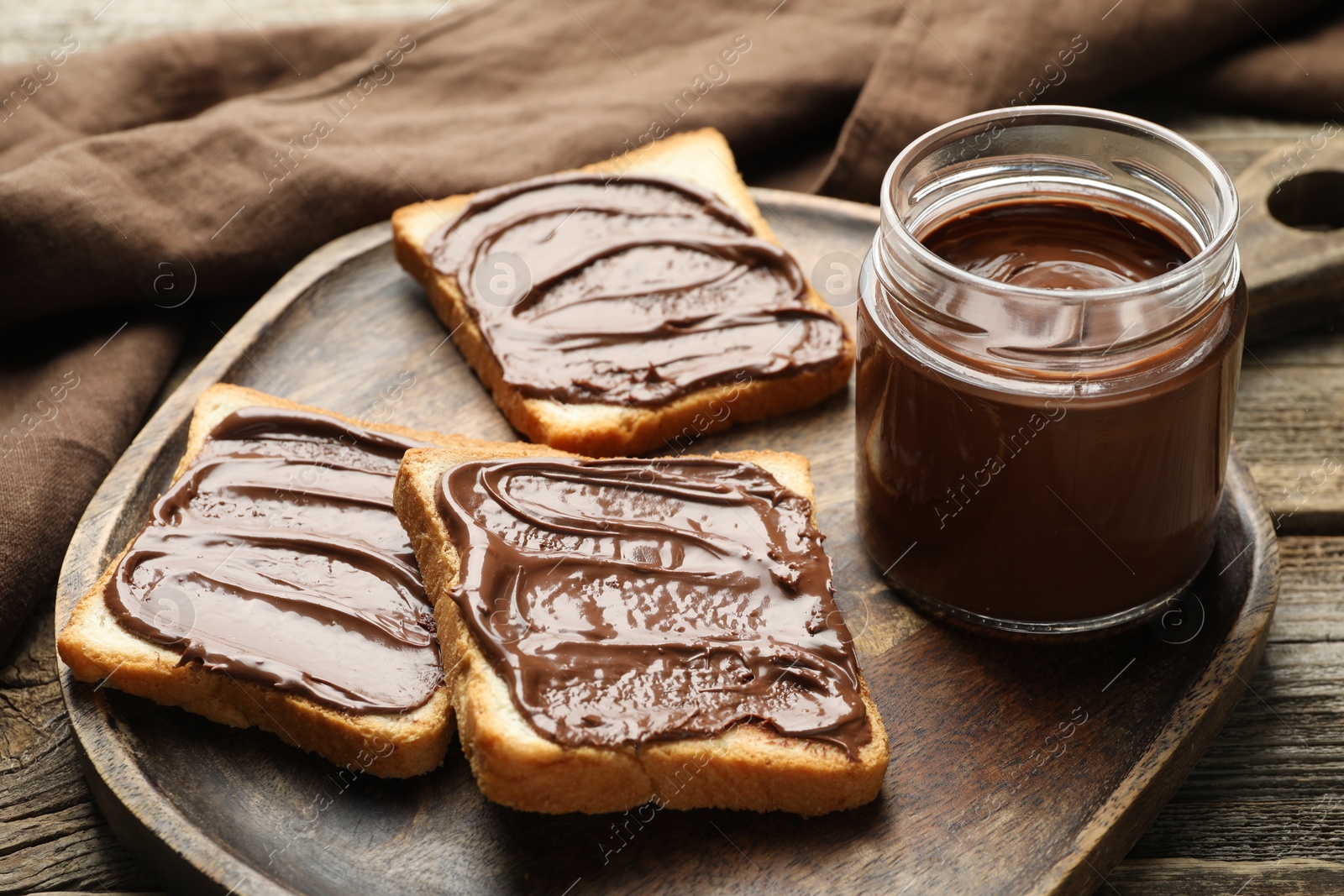 Photo of Tasty sandwiches with chocolate butter on wooden table, closeup