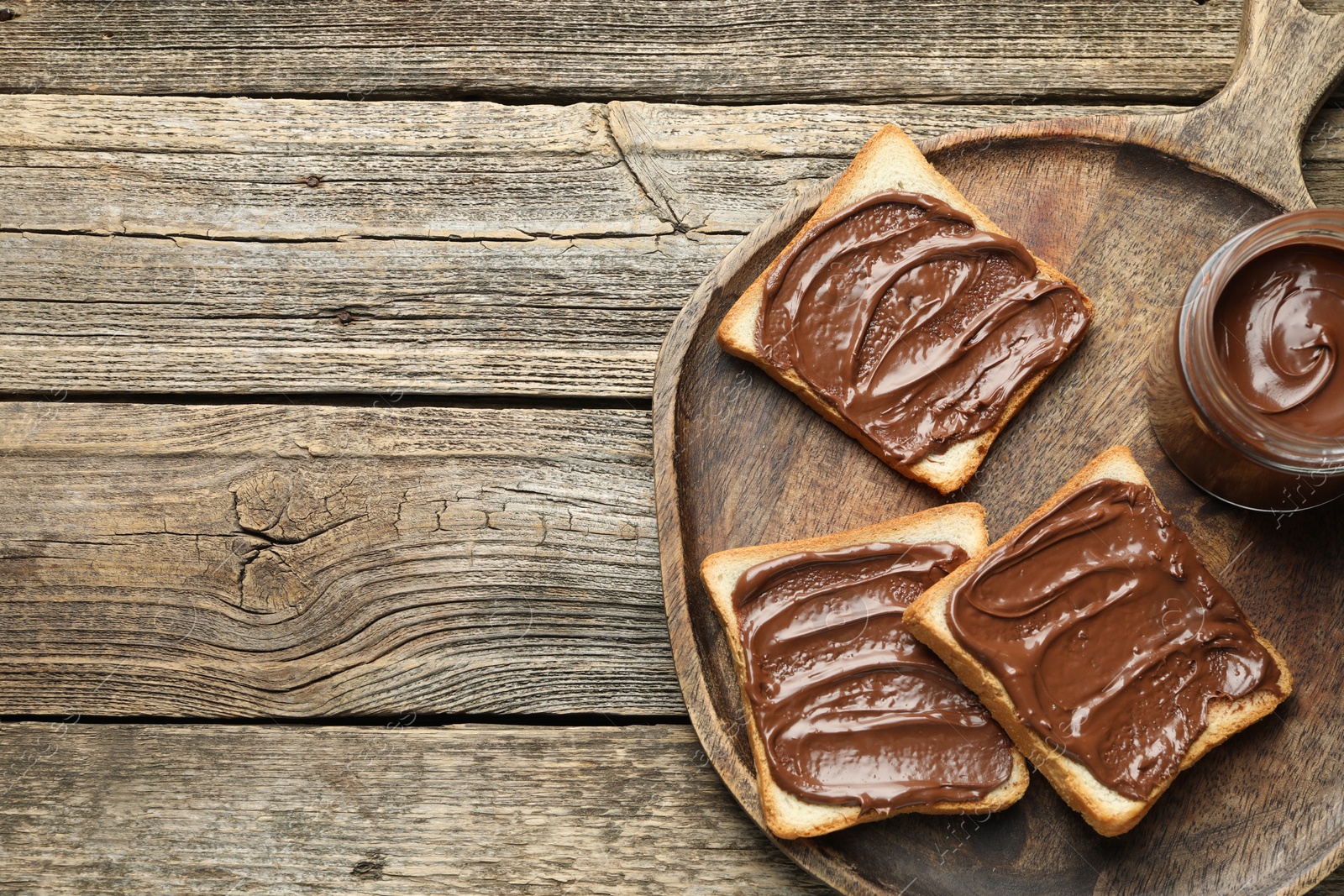 Photo of Tasty sandwiches with chocolate butter on wooden table, top view. Space for text