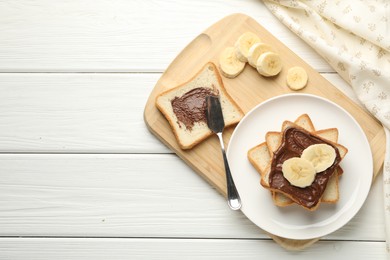 Photo of Sandwiches with chocolate butter and banana on white wooden table, top view. Space for text