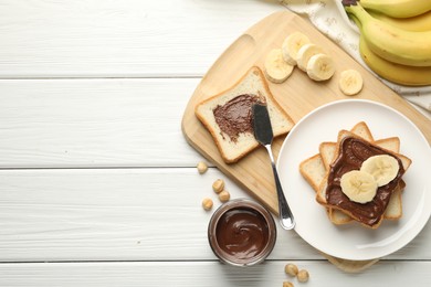 Photo of Sandwiches with chocolate butter, bananas and hazelnuts on white wooden table, flat lay. Space for text