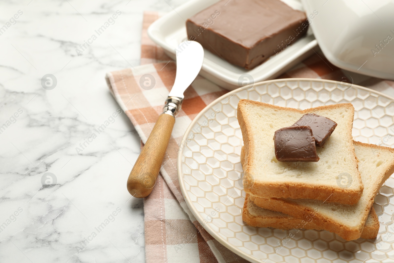 Photo of Sandwiches with chocolate butter and knife on white marble table, closeup. Space for text