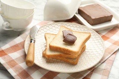 Photo of Sandwiches with chocolate butter and knife on white marble table, closeup