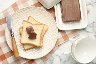 Photo of Sandwiches with chocolate butter and knife on white marble table, flat lay