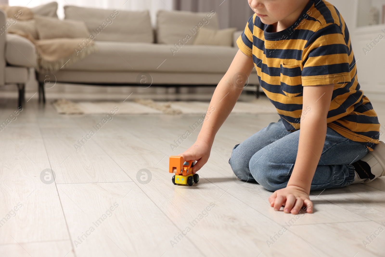 Photo of Little boy playing with toy car at home, closeup. Space for text