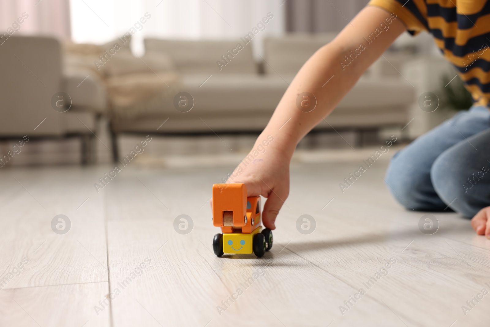 Photo of Little boy playing with toy car at home, closeup. Space for text