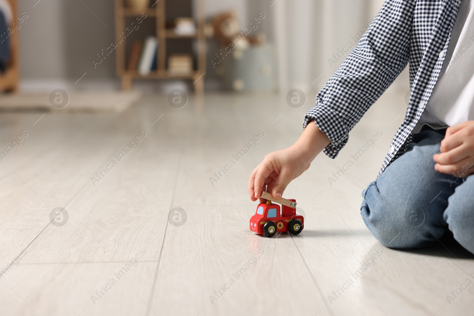 Photo of Little boy playing with toy car at home, closeup. Space for text