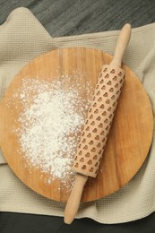 Photo of Wooden rolling pin, board and flour on gray table, top view