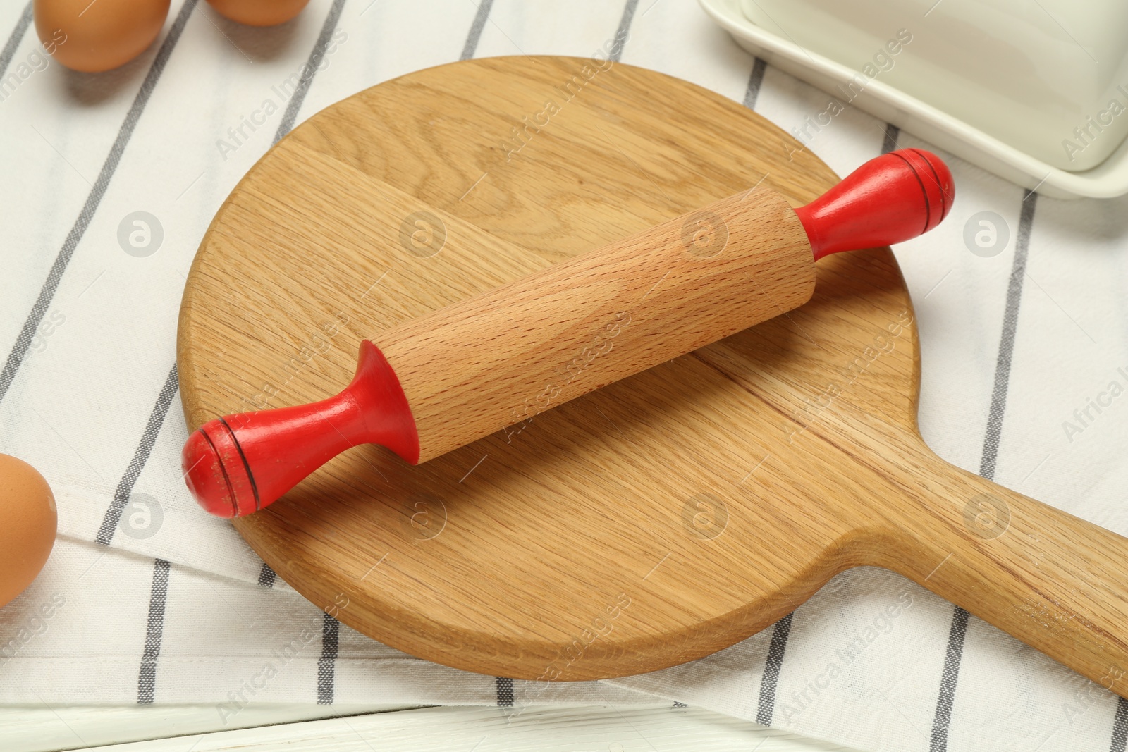 Photo of Rolling pin and wooden board on table, closeup