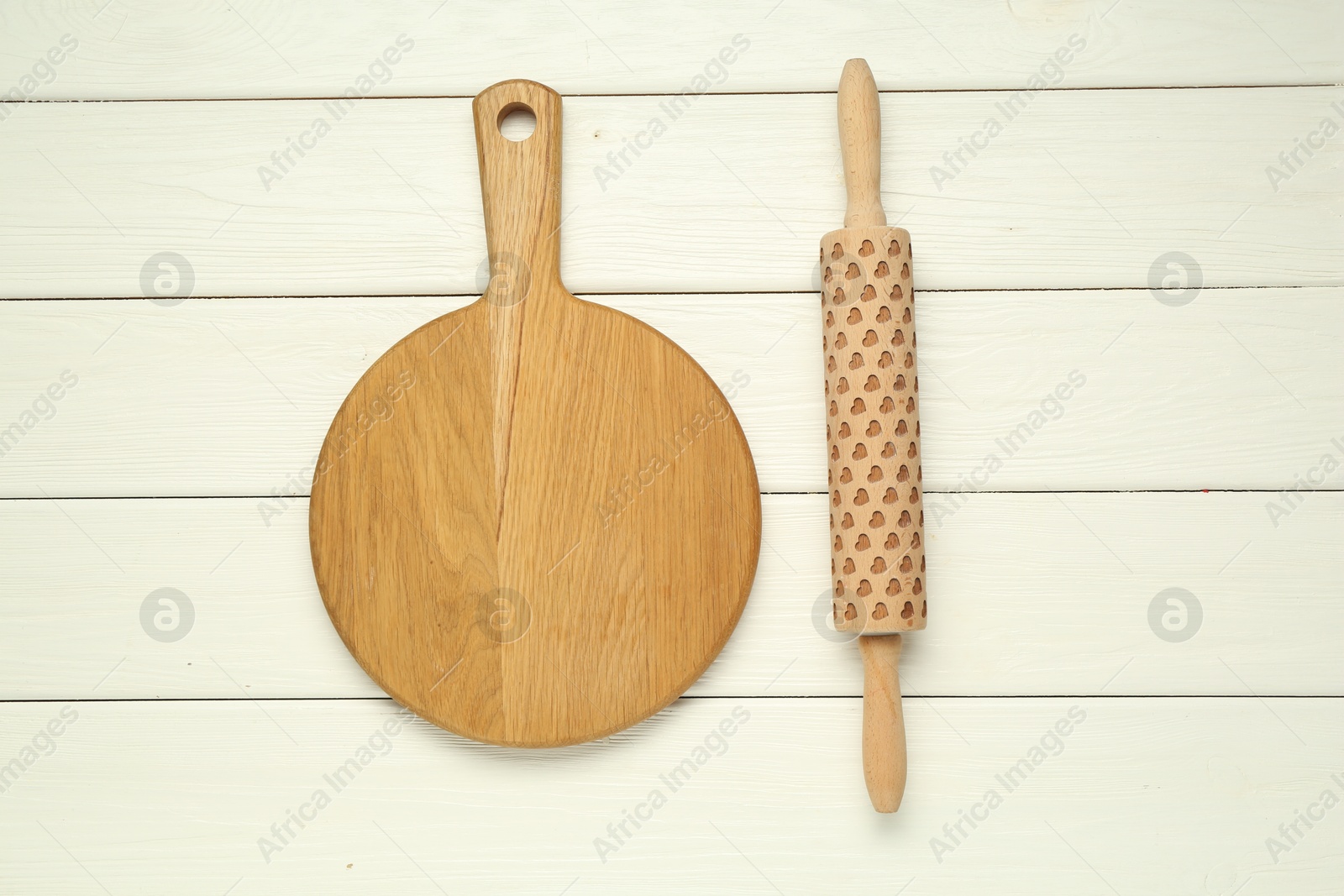 Photo of Rolling pin and board on white wooden table, flat lay