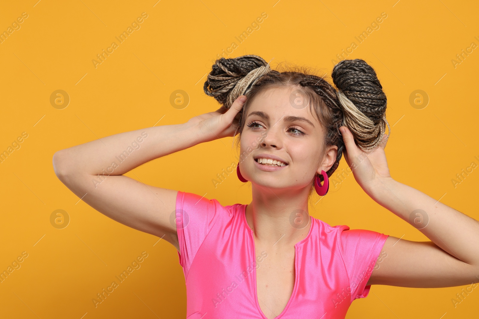 Photo of Beautiful woman with braided double buns on yellow background