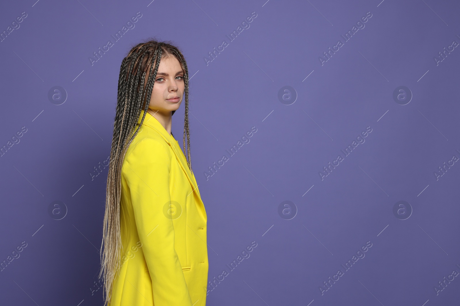 Photo of Beautiful woman with long african braids on purple background, space for text